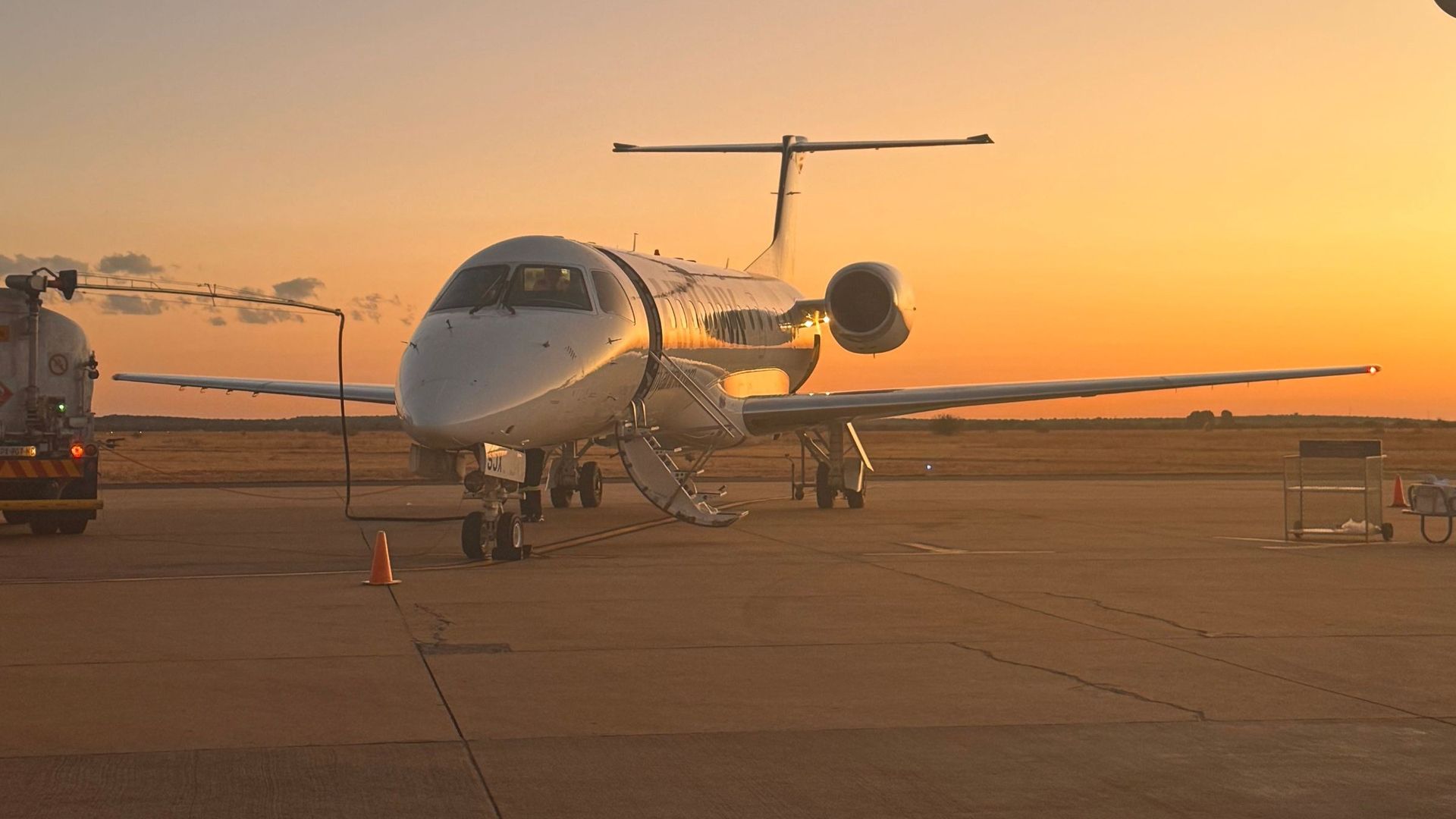 Business jet on the ramp at sunset with a fuel truck connected
